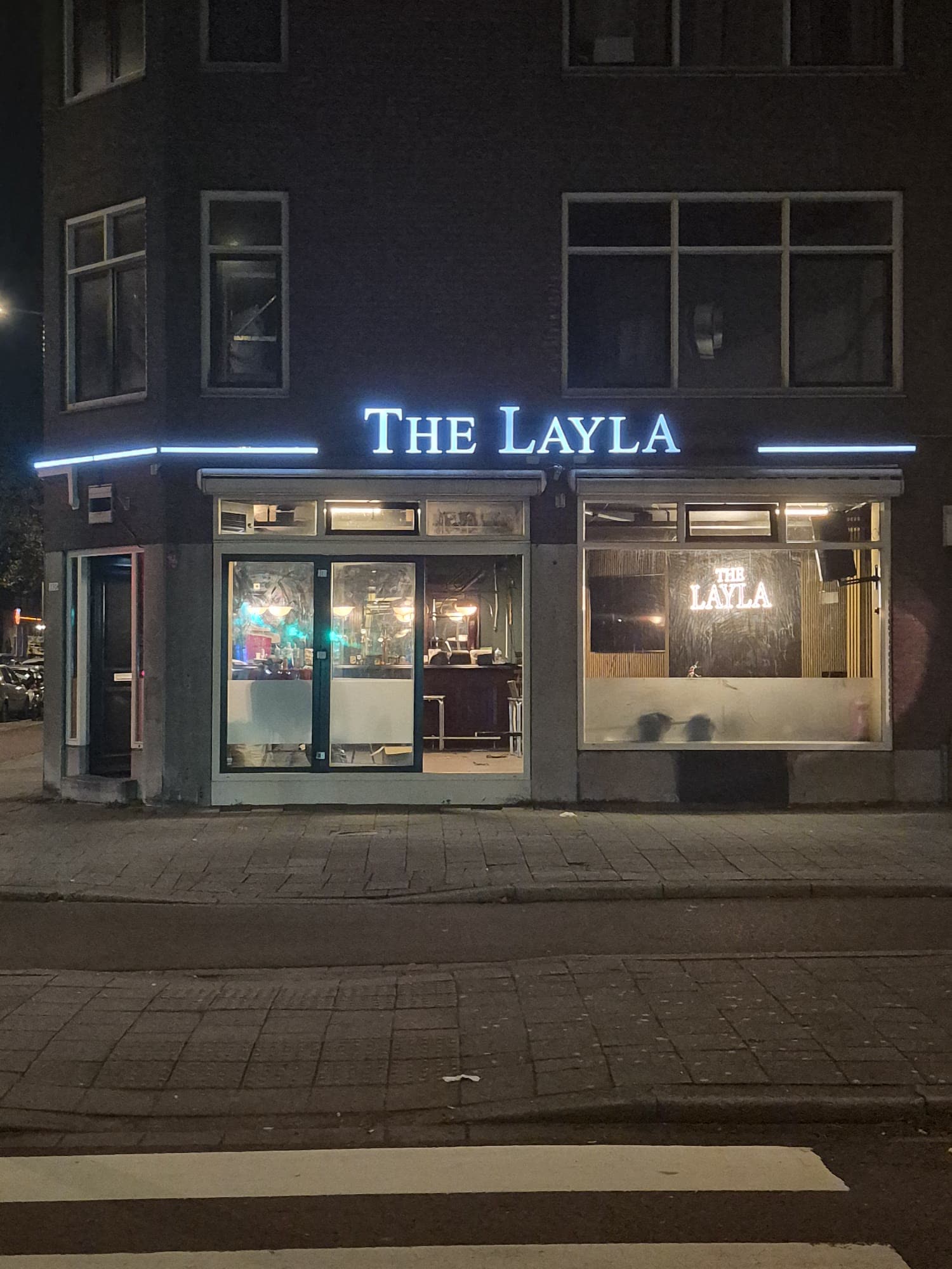 Voorzijde van The Layla met verlichte gevelletters boven de entree