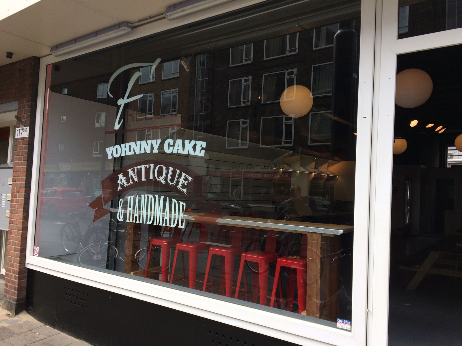 Raambelettering etalage Yohnny Cake — Antique & Handmade — cafe in Rotterdam met handlettering en logo op groot etalageraam